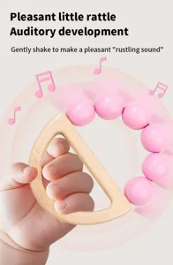 Close-up of wooden rattle toy with pink beads, baby hand grip detail for early learning.