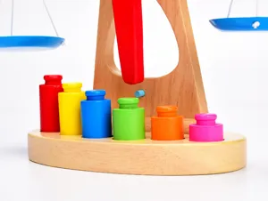 Close-up detail of the wooden Montessori balance scale toy featuring colorful cylindrical weights.