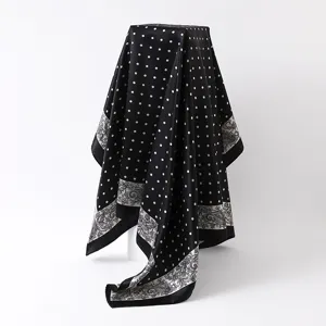 Black and white polka dot and paisley printed satin square scarf fabric detail view.