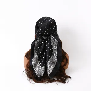 Detail view of the black satin square scarf featuring a stylish polka dot and paisley mix.