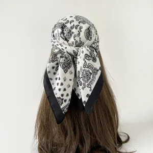Black and white paisley print square scarf detail showing the elegant tied bandana styling.