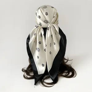 Detailed view of a black and white floral silk scarf styled as an elegant chic headscarf.