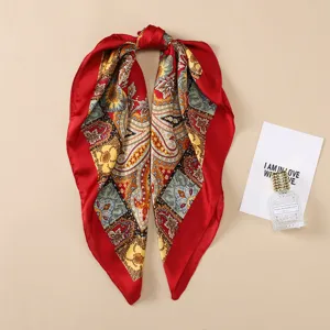 Detail shot of a red paisley print silk-like square scarf, elegant neckerchief texture closeup