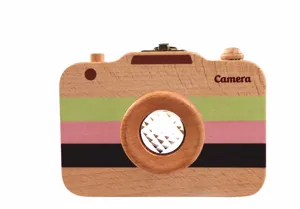 Détail de l'appareil photo jouet en bois, avec blocs colorés et lentille kaléidoscope.