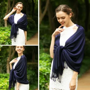 Detailed view of women solid color imitation cashmere tassel shawl in dark blue color outdoor.