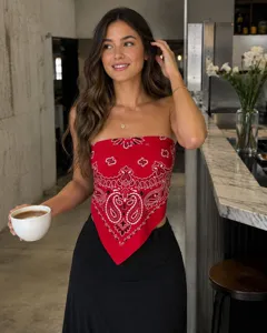 Detailed view of a vibrant red paisley bandana styled as a trendy strapless tube top in cafe.