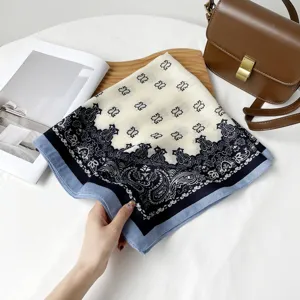 Detail shot of a stylish 68cm square scarf with classic paisley print and elegant blue border.