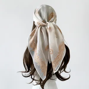 Detailed close-up view of the retro paisley print square scarf tied elegantly on hair.