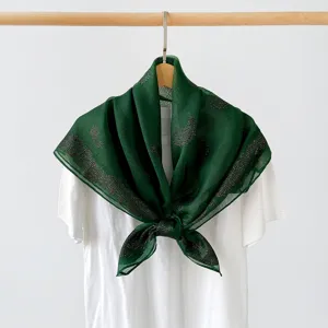 Dark green paisley square scarf detail showcasing elegant metallic pattern and fabric texture.