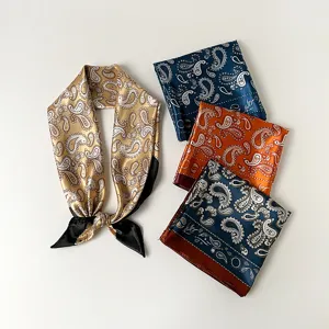 Close-up detail of paisley satin square scarves, featuring delicate vintage print texture.