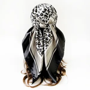 Leopard print satin square scarf detail shot, elegant black and white silk feel headscarf.