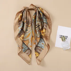 Silk scarf detail showing classic paisley print, elegant beige border design for women.