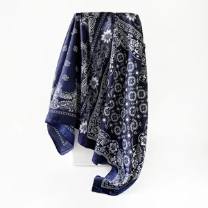Détail de foulard en soie paisley bleu foncé, motif floral élégant, texture douce.