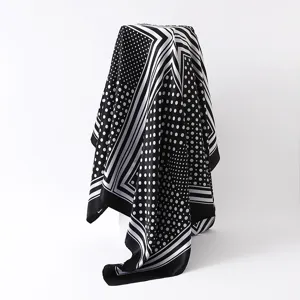Gedetailleerd overzicht van de zwart-witte sjaal met polkadots en mooi gedrapeerde stofstructuur.