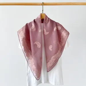Detailed shot of a 90cm vintage paisley square scarf, elegant mauve silk-like shawl design.