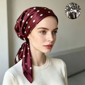 Close-up detail of the burgundy polka dot satin headscarf cap, showing interior elastic.