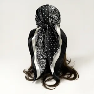 Detail view of black and white paisley and polka dot silk scarf worn as a stylish head wrap.