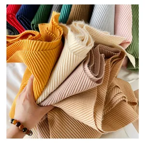 Gedetailleerd overzicht van geplooide, kasjmier-achtige effen sjaalstoffen in diverse kleuren.