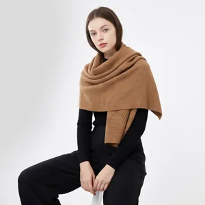 Gedetailleerd overzicht van een zachte, kasjmierachtige camelkleurige wintersjaal op model.