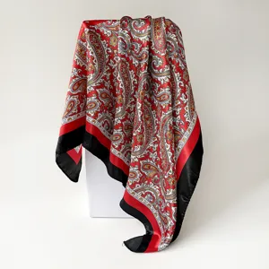 Detailed view of red paisley print square scarf, elegant draped fabric texture showcase.