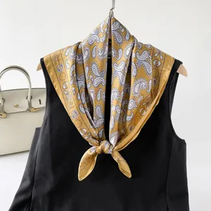 Vue detaillee du foulard carre en soie a motif cachemire jaune, satin doux et elegant.