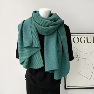 Gedetailleerd overzicht van de donkergroene geplooide wintersjaal in elegante stijl.