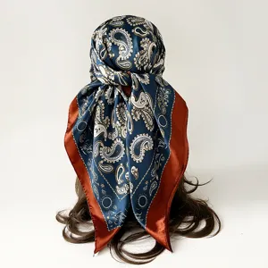 Detail view of a 90cm satin paisley square headscarf, elegant dark blue and rust brown shawl.