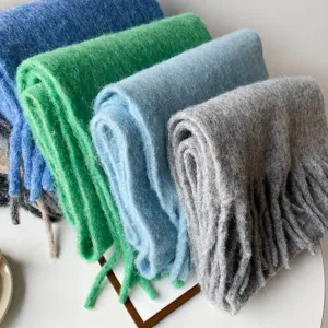 Close-up detail of soft fluffy winter mohair scarf with fringe in multiple solid colors.