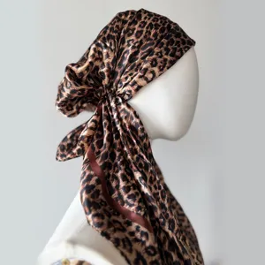 Detail view of leopard print satin headscarf showcasing smooth fabric texture and drape.