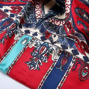 Close-up view of the classic paisley printed silk square scarf, vibrant red and blue details.