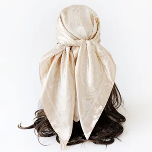 Detail view of the elegant beige paisley satin square scarf, showcasing smooth draping effect.
