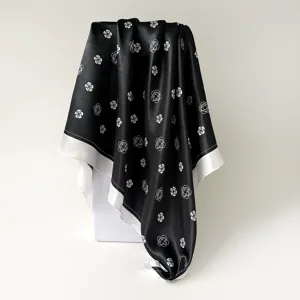 Elegant black satin square silk scarf featuring a chic white camellia floral design.