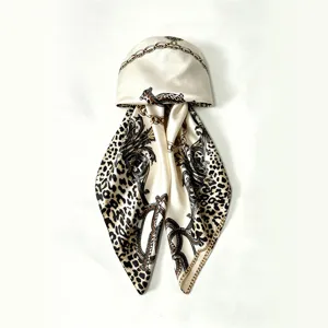 Detailed view of luxury silk satin headscarf featuring chic leopard and gold chain print.