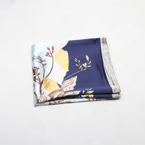 Silk square scarf detail showing delicate botanical shell print and two-tone blue silk fabric.