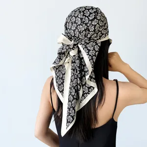 Detaillierte Rückansicht eines schwarz-weißen Paisley-Dreiecktuchs, getragen von einem Model.