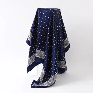 Silk scarf detail showcasing blue polka dot and paisley print design for women fashion.