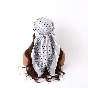 Satin square scarf featuring classic black polka dots and intricate paisley border design.
