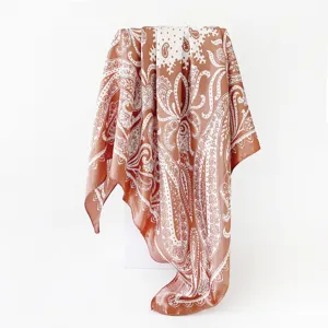 Detailed shot of brown and white paisley print satin square scarf, elegant fabric texture.