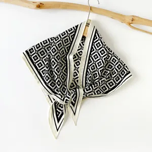 Chic black and white printed silk square scarf with elegant floral pattern for women.