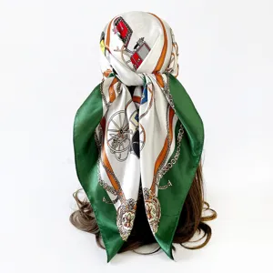 Luxurious silk scarf featuring an elegant carriage and chain print with a bold green border.