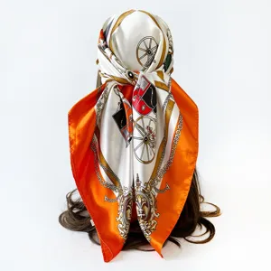Close-up detail of luxury silk scarf showing elegant carriage chain print design pattern.
