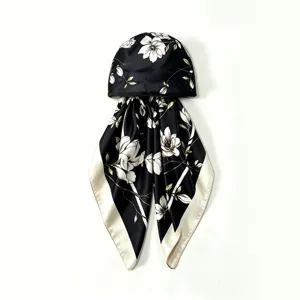 Detailed view of black satin head scarf cap featuring elegant white floral and branch print.