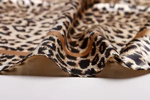 Close-up of luxury leopard print satin square scarf showing exquisite rolled edges and soft drape.