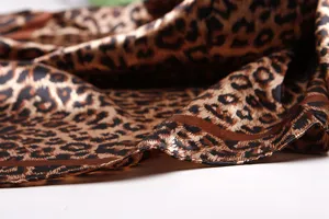 Leopard print satin scarf detail shot, showing smooth texture and exquisite hemming work.