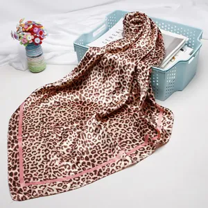 Leopard print satin square scarf detail showing smooth texture, stylish pink border and chic drape.