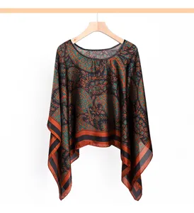 Detailed view of the vintage paisley print cape, showcasing intricate teal and rust patterns.