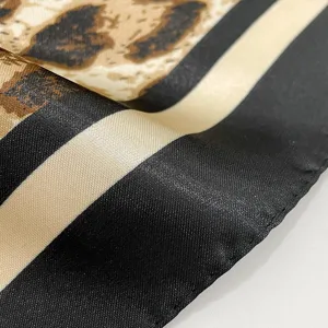 Detailed close-up shot showcasing the luxurious leopard print and striped satin silk scarf texture.