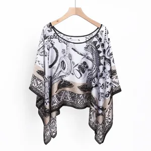 Detailed view of women black white printed sun protection poncho shawl with delicate trim.