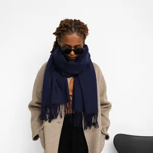 Detailed view of a dark blue solid color tassel scarf, elegant winter warm design.