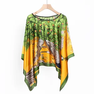 Detailansicht eines Ethno-Ponchos aus Satin mit lebhaftem Pfauenfeder-Print Design